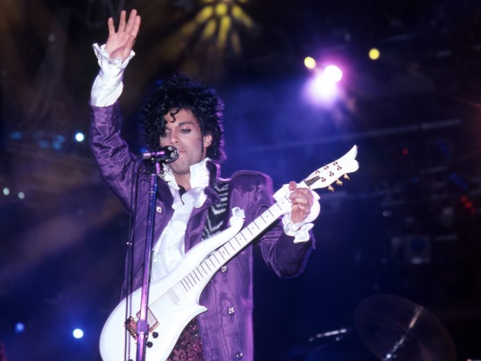 Prince performing live onstage during his 'Purple Rain' tour in 1984
